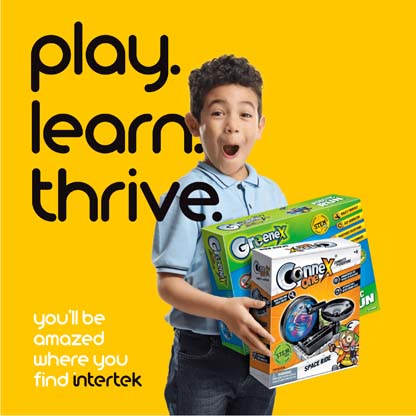A young boy smiling while holding several boxes of toys